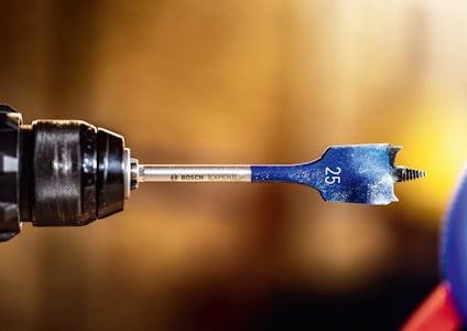 Borr med svarta och blå detaljer, märkningen "Bosch Expert 25" synlig, monterad i en borrmaskin.