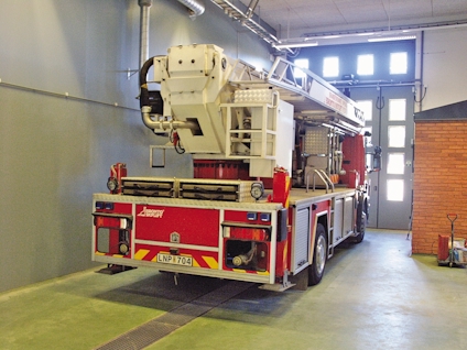 Brandbil med stege parkerad inomhus. Registreringsskylt LNP 704 synlig.