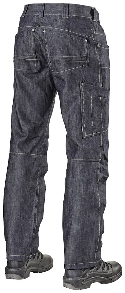 Person i mörka jeans med svarta skor, stående med ryggen mot kameran.