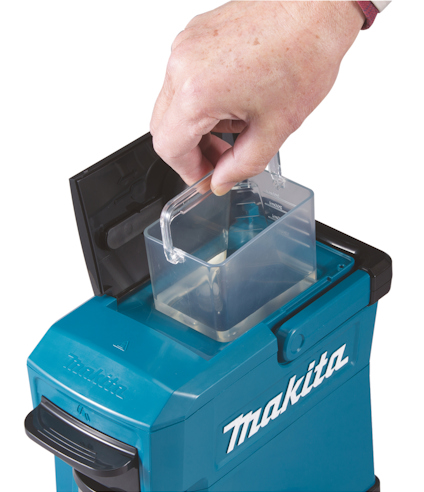 En hand placerar en behållare i en blå Makita-apparat.