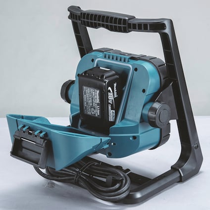 Bärbar blå och svart fläkt med svart sladd, laddningsbart batteri och handtag. Märkt med "Makita".