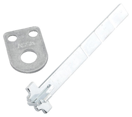 Metallkomponenter, en platt platta med två runda hål och texten "ASSA", samt en lång, vinklad metallstång.