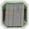 Staples neatly stacked in a green container secured with a yellow rubber band.