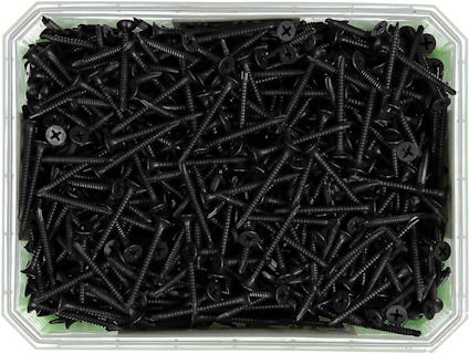 Antal svarta skruvar med stjärnformade skallar i en plastlåda.