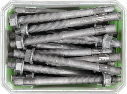 Metallskruvar och expansionsexpansionsbultar i en plastlåda.