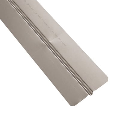 Metallplåt lagd mot en brun, texturerad yta.
