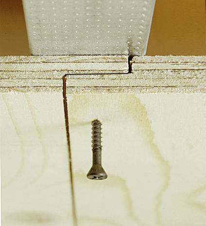 Monterad väggplywood på regel, en skruv genom falsen som fäster i regeln.