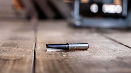 Metallborr liggande på ett träbord med suddig bakgrund.