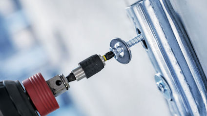 Borrmaskin som skruvar in en skruv i en metallram.