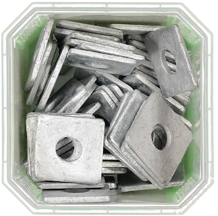 Fyrkantiga metallbrickor staplade i en transparent plastbehållare.