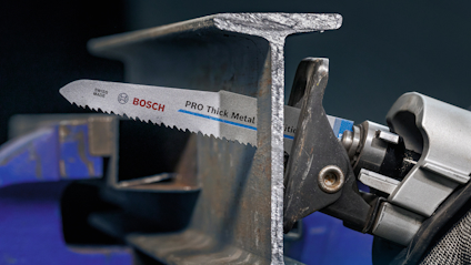Sågklinga från Bosch monterad i verktyg, bredvid ett metallstycke formad som ett H.